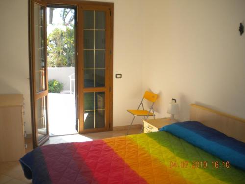 a bedroom with a bed with a colorful blanket at Appartamento in VILLA spazio esterno e posto auto in Rio nellʼElba