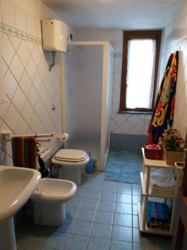 a bathroom with a toilet and a sink at Appartamento in VILLA spazio esterno e posto auto in Rio nellʼElba