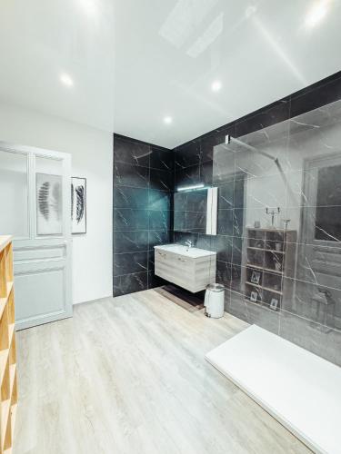 a large bathroom with a sink and a tub at La Canopée in Verdun-sur-Meuse
