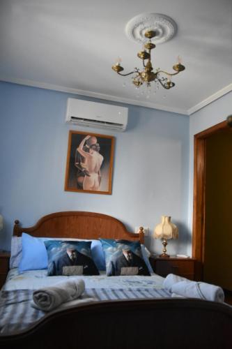 a bedroom with a bed with blue walls and a ceiling at O recuncho - Alojamiento tranquilo cerca de Ribeira Sacra y Ourense in Maceda