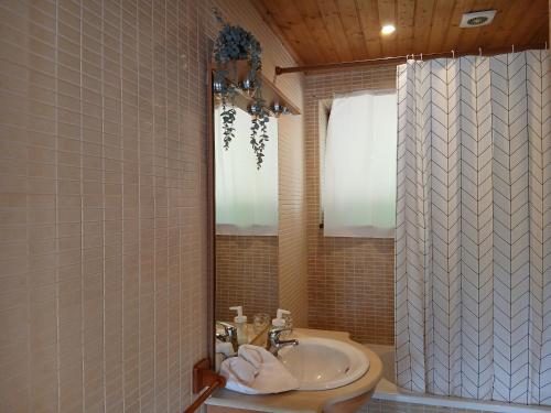 a bathroom with a sink and a shower curtain at Gerês by Papitravel in Vieira do Minho