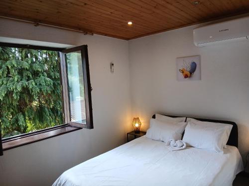 a bedroom with a white bed and a window at Gerês by Papitravel in Vieira do Minho