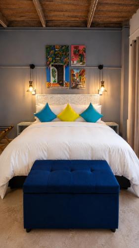a bedroom with a large bed with blue and yellow pillows at Maloka Boutique Centro Histórico in Cartagena de Indias