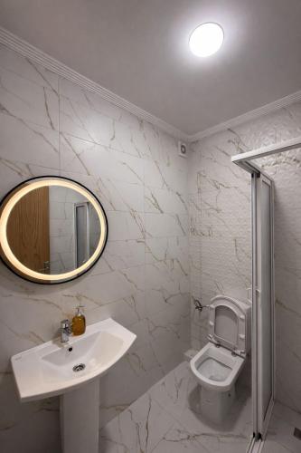 a bathroom with a sink and a toilet and a mirror at Asilah in Asilah
