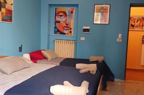 two beds in a room with blue walls at La capannina cilento num 11 in San Marco di Castellabate