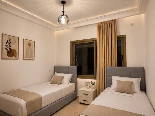 a bedroom with two beds and a window at Asilah in Asilah