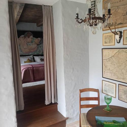 a dining room with a table and a bedroom with a bed at LE LIT DE LA SEMOY Chassepierre in Chassepierre