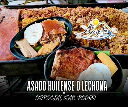 a table with two trays of food with meat and eggs at Restaurante - Hotel Los Manguitos in Rivera