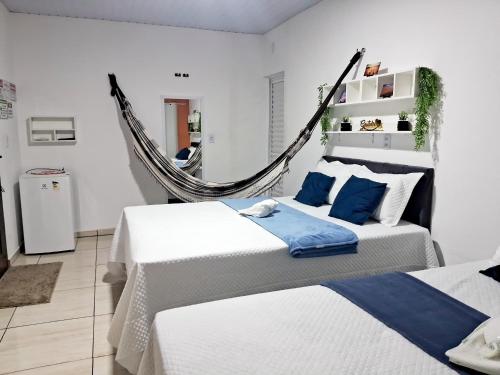 a bedroom with two beds and a hammock at Hospedagem Aconchego Do Lar in Barreirinhas