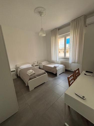 a room with two beds and a table and chairs at Residence Carmen in Falconara Marittima