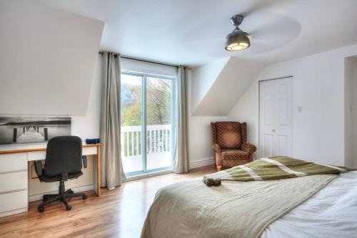 a bedroom with a bed and a desk and a chair at Country house with SPA, small beach, pool in Mont-Tremblant