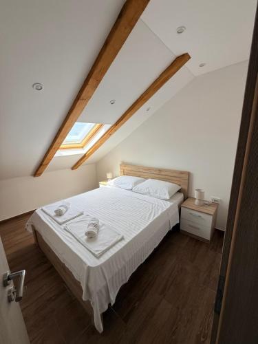 a bedroom with a large bed in a attic at Apartman Lucija 5 in Zubovići