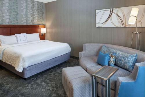 a hotel room with a bed and a couch at AmericInn by Wyndham Brookfield in Brookfield