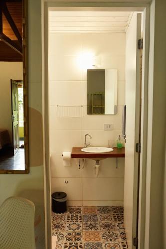 a bathroom with a sink and a mirror at Pousada Rancho da Serra PETAR in Iporanga