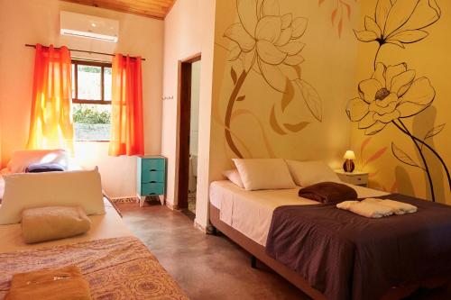 a bedroom with a bed with a flower mural on the wall at Pousada Rancho da Serra PETAR in Iporanga