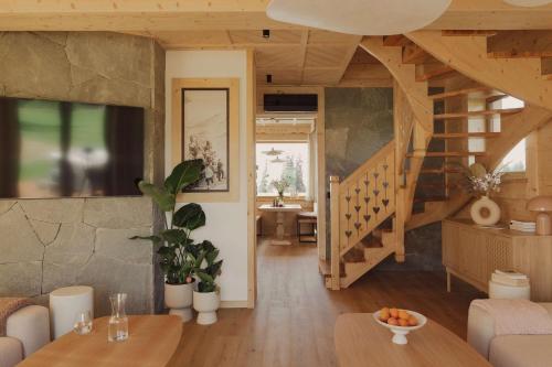 a living room with a staircase and a table at Lovelia Luxury Chalet & Jacuzzi in Zakopane