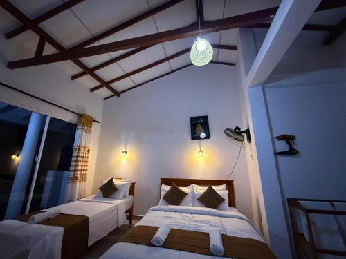a bedroom with two beds in a room at Senu Ceylon Ella in Ella