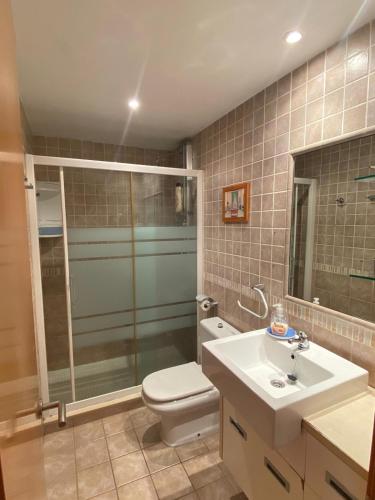 a bathroom with a toilet and a sink and a shower at PRIMERA LINEA DE PLAYA VILAFORTUNY in Vilafortuny