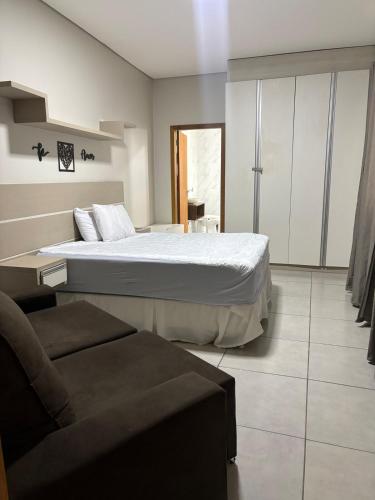 a bedroom with a large bed and a couch at Recanto R2V in Chapada dos Guimarães