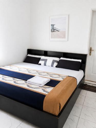 a bed in a room with a black frame at Caligeo Suites I in Ibadan