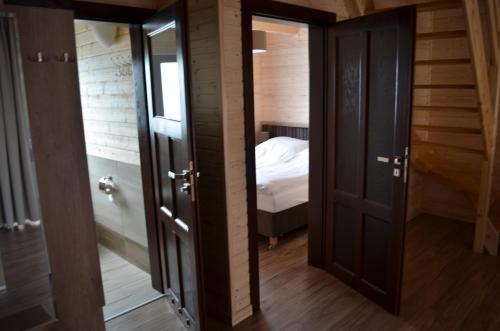 un corridoio con due porte e un letto in una stanza di OW Wiktoria a Rogowo