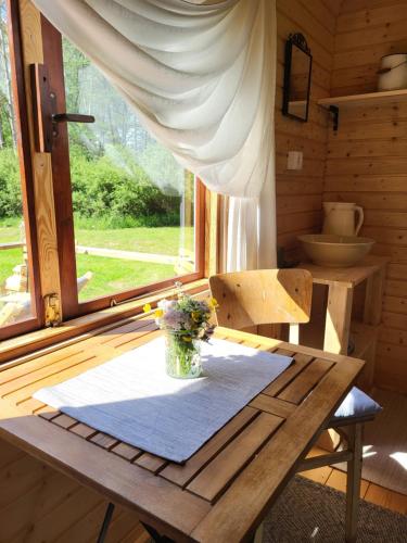 a wooden table with a vase of flowers on it at Glamping Maringotka77 in Protivec