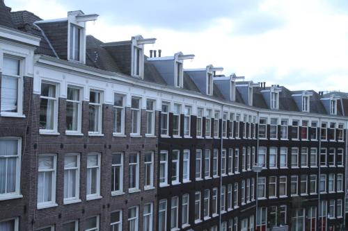uma fila de edifícios de tijolos com janelas brancas em Olive Bed and Breakfast em Amsterdã