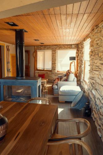 a living room with a couch and a stone wall at Black Hills Caviahue in Caviahue