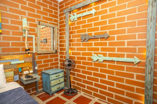 a room with a brick wall with a bed and a window at Hotel Alto lindo in Guatapé