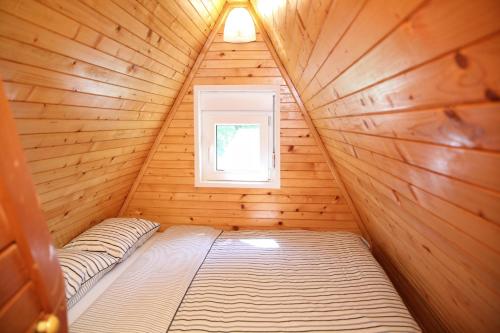 a bedroom in a log cabin with a window at Vila Zeleno borje in Žabljak