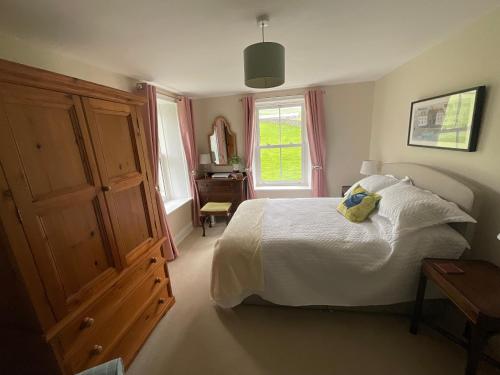 a bedroom with a white bed and a window at Dale Grange in Askrigg