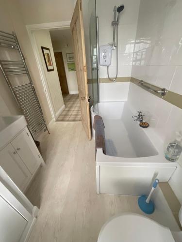 a bathroom with a white tub and a toilet at Dale Grange in Askrigg