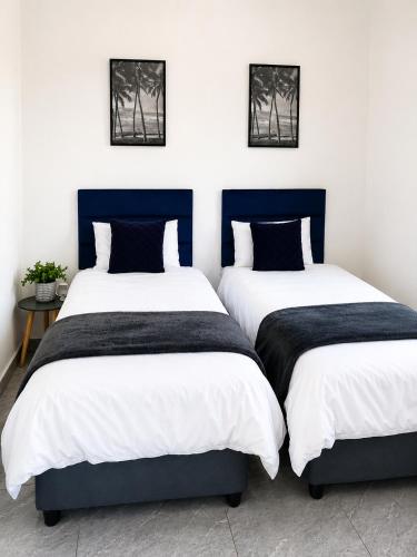 two beds sitting next to each other in a bedroom at 60 On Kosmos in Bellville South