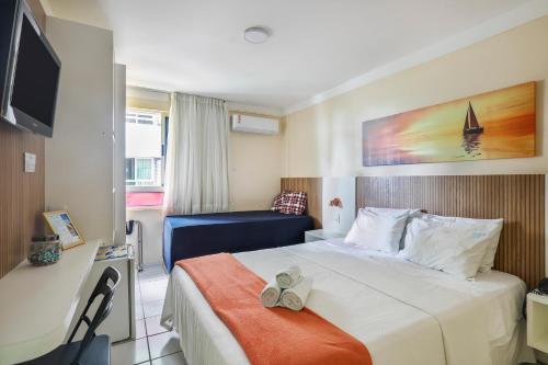 a hotel room with a bed with shoes on it at Mar de Ponta Negra in Natal