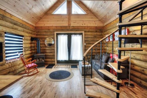 a room with a staircase in a log cabin at Log cabin with SPA, pool, and small beach in Mont-Tremblant