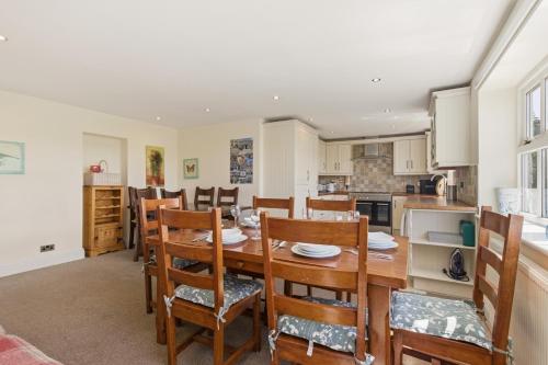 a kitchen and dining room with a wooden table and chairs at Ghyllstead - North East Escapes in Glanton