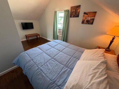 a bedroom with a bed with a blue comforter at Strip Location Pet Friendly Fire Pit in Geneva