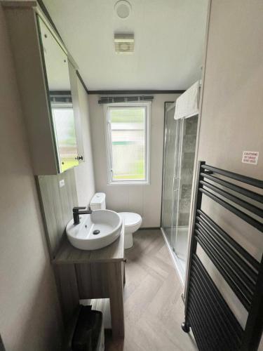 a bathroom with a sink and a shower and a toilet at Hardy's Hut in Felton