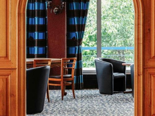 a dining room with chairs and a table and a window at Mercure Nevers Pont De Loire in Nevers