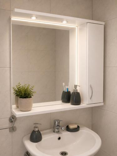 a bathroom sink with a mirror and a white cabinet at Vikendica Bregovi in Doboj