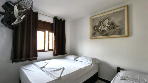 a bedroom with two beds and a window at Hotel Silveira in Guarapari