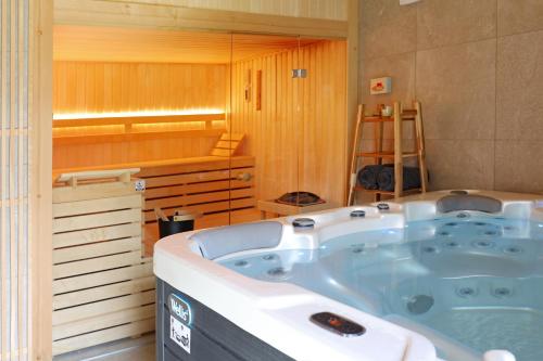 a bath tub in a room with a sauna at Wellness Chalupy LETOKRUHY in Jeseník