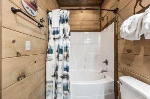 a bathroom with a tub and a toilet and a sink at Splash N Heavenly Views in Gatlinburg