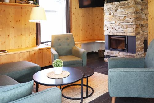 a living room with chairs and a table and a fireplace at Wellness Chalupy LETOKRUHY in Jeseník