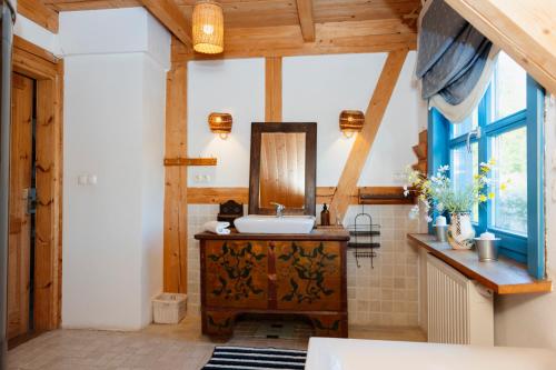 a bathroom with a sink and a mirror at Siedlisko Pod Strzechą in Wólka