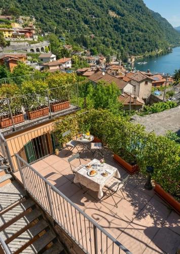 a patio with a table and chairs on a balcony at NEW Larioview suites in Argegno