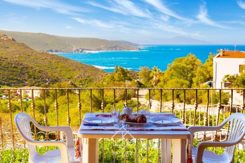 a table on a balcony with a view of the ocean at Dimora Cala-Vista in Torre Dei Corsari