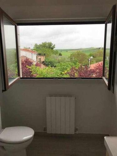 a bathroom with a toilet and a large window at Casa Zacarias - Bonitas vistas en La Rioja in Herramélluri