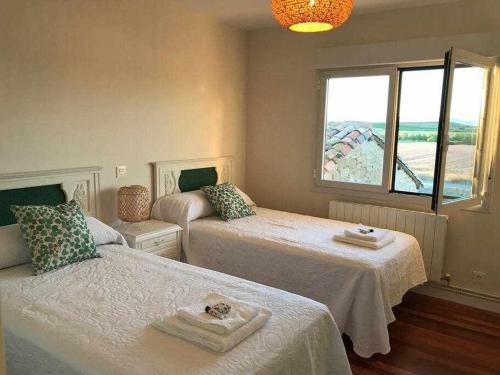 a bedroom with two beds and a window at Casa Zacarias - Bonitas vistas en La Rioja in Herramélluri