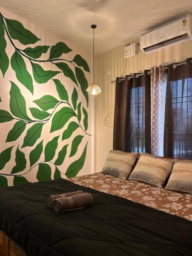 a bedroom with a large bed with a green and white wall at Oak & olive stays in Tezpur
